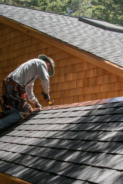 Modern suburban home in Charleston, SC during roof installation, with professional roofer at work.